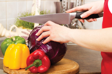  housewife cuts red cabbage at home