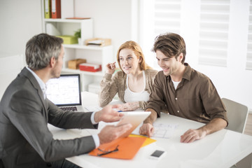 real-estate agent receives a young couple interested to invest i