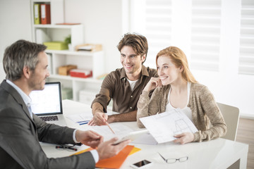 Obraz premium real-estate agent receives a young couple interested to invest i