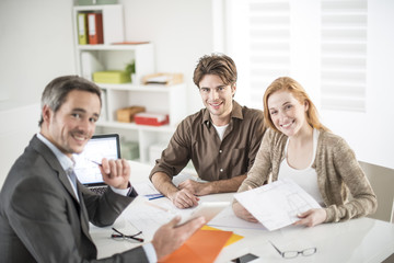 real-estate agent receives a young couple interested to invest i