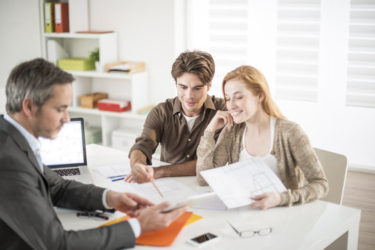 real-estate agent receives a young couple interested to invest i