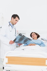 Doctor showing x-ray to female patient