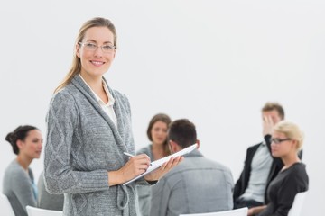 Fototapeta premium Portrait of therapist with group therapy in session in backgroun