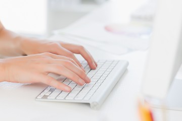 Close-up of hands using computer keyboard in office