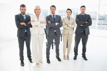 Confident business team with arms crossed in office