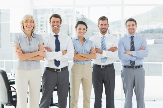 Confident business team with arms crossed in office
