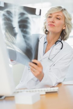 Serious female doctor examining x-ray