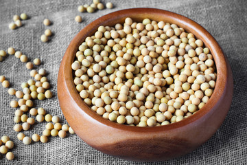 Soybeans in wooden bowl on linen canvas