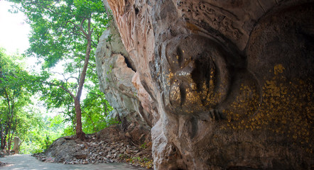The stucco of ancient reclining Buddha at the Khao Ngu Cave in T