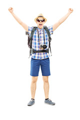 Smiling male hiker with raised hands gesturing happiness