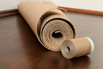 Roll of cork with Painting edging tape lies on a brown floor
