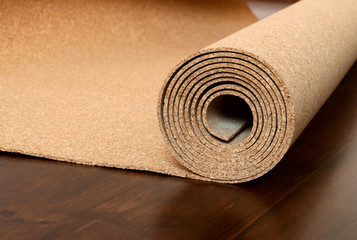 Roll of cork lies on a brown floor