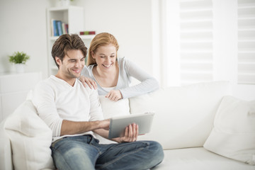 cheerful couple watching a digital tablet