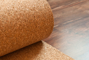 Roll of cork lies on a brown floor