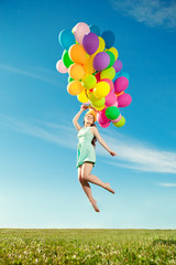 Luxury fashion woman with balloons in hand on the field against