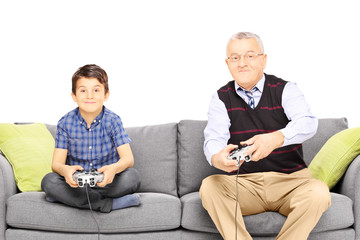 Grandfather with his nephew seated on a modern sofa playing