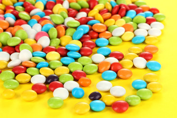 Fototapeta na wymiar Colorful candies on yellow background