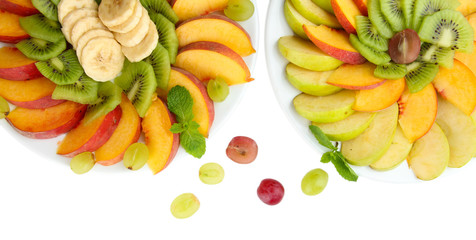 Assortment of sliced fruits on plates, isolated on white