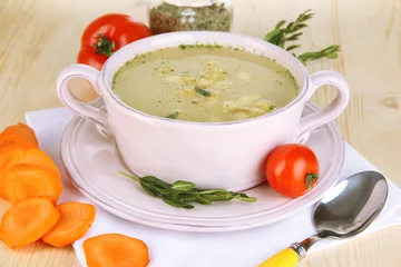 Cercles muraux Herbes 2 Soupe nourrissante dans une casserole rose avec des ingrédients