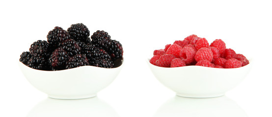 Ripe raspberries and blackberries in bowl isolated on white