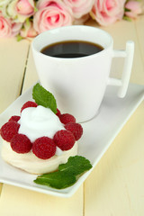 Tasty meringue cake with berries and cup of coffee,