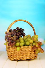 Fresh grape on wicker mat on bright background