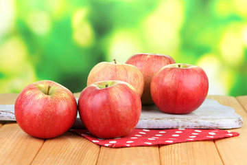 Ripe apples on  wooden table, on bright background
