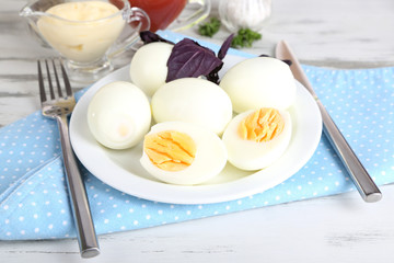 Boiled eggs on plate on napkin on wooden table