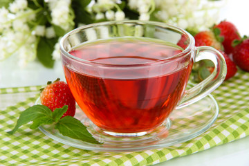Delicious strawberry tea on table close-up
