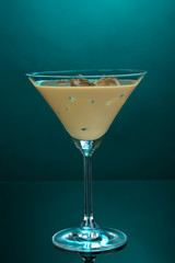 Baileys liqueur in glass on blue background