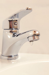 Close-up of human hands being washed under faucet in bathroom,