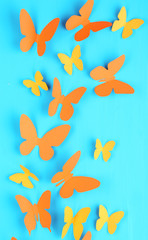 Paper butterflies on blue wooden board background