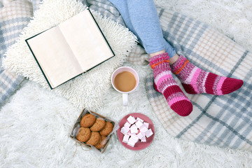 Fototapeta na wymiar Composition with warm plaid, book, cup of hot drink and female