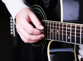 Fototapeta premium Acoustic guitar in female hands, close-up