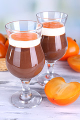 Dessert of chocolate and persimmon on table on light background
