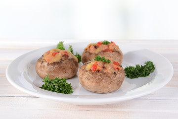 Stuffed mushrooms on plate on table on light background