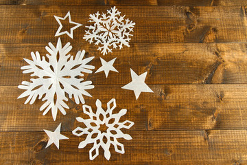 Beautiful paper snowflakes on wooden background