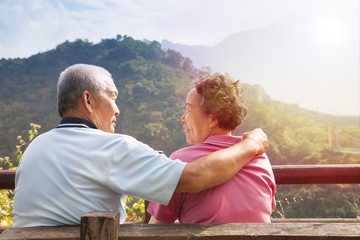 senior couple sitting on the bench in nature park