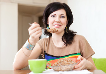 Obraz na płótnie Canvas woman eats buckwheat porridge