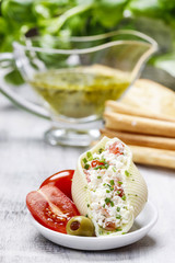Italian cuisine: stuffed pasta shells and stack of breadsticks.