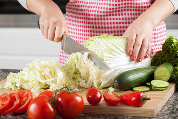 Woman's hands cutting lettuce
