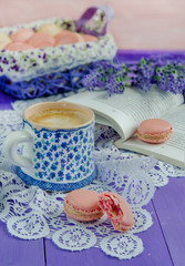 Colored macaroon and cup of coffee on wooden table