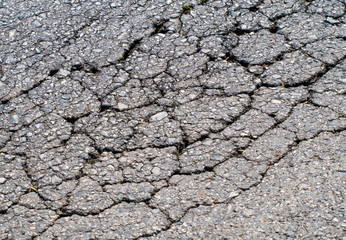 Old worn and cracked asphalt with cracks