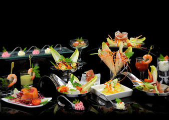 Various elegant gourmet dishes on black background