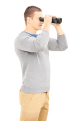 Smiling casual man looking through binocular