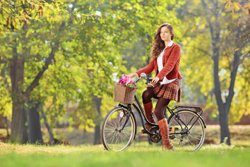 Obraz premium Young female on a bicycle in a park