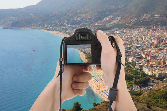 camera in male hands taking picture of beautiful landscape