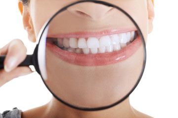 Beautiful woman with magnifying glass showing her perfect white