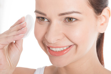 Obraz premium Young beautiful cleaning face with cotton pads.