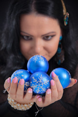 Fototapeta na wymiar Christmas tree baubles in womans hands. Focus on baubles.